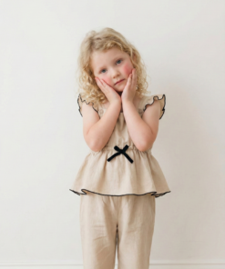 Enterito crudo con detalles negros de bengalina Jumpsuit Alice, con moño negro y volados en bota