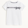 Remera infantil blanca de jersey con moño cuadrillé negro y blanco en el pecho