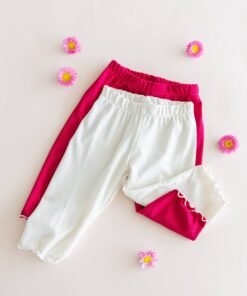 Dos calzas ciclistas infantiles de tela morley, color blanco y color fucsia magenta, mostrando el detalle del ruedo con terminación ruloté.