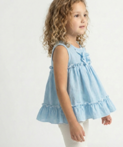 Niña con cabello rizado usando una blusa celeste sin mangas de tela gasa tipo lino, con volados y bordes blancos festoneados. Ropa de verano elegante para niñas.
