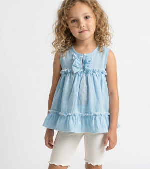 Niña con cabello rizado usando una blusa celeste sin mangas de tela gasa tipo lino, con volados y bordes blancos festoneados. Ropa de verano elegante para niñas.